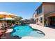 Resort-style backyard with a pool, lounge area, rock waterfall, and vibrant landscaping at 19461 N Rose Rd, Maricopa, AZ 85138