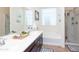 Bathroom with dual sinks, soaking tub, glass-enclosed shower, and decorative accents at 19461 N Rose Rd, Maricopa, AZ 85138