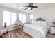 Bright bedroom features wood floors, ceiling fan, neutral walls, and stylish vanity at 19461 N Rose Rd, Maricopa, AZ 85138