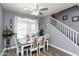 Charming dining room with a table set for six, elegant decor, and a view of the staircase at 19461 N Rose Rd, Maricopa, AZ 85138