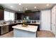 Well-lit kitchen with a central island, dark wood cabinets, stainless steel appliances, and a pantry at 19461 N Rose Rd, Maricopa, AZ 85138