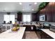 Modern kitchen boasts stainless steel appliances, dark cabinetry, and a large island with white marble countertops at 19461 N Rose Rd, Maricopa, AZ 85138