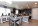 Open kitchen featuring a coffee bar, dark cabinets, and a dining area with seating for four at 19461 N Rose Rd, Maricopa, AZ 85138