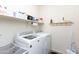 Well-equipped laundry room with modern washer and dryer, and storage shelves at 19461 N Rose Rd, Maricopa, AZ 85138