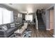 Comfortable living room with gray sofa, stylish furniture, and staircase access for a cozy, inviting space at 19461 N Rose Rd, Maricopa, AZ 85138