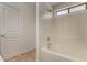 Close up shot of the bathtub/shower with white tile, and white door to the left at 23682 W Bowker St, Buckeye, AZ 85326