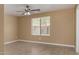 Neutral-toned bedroom with tile flooring, a ceiling fan, and a window offering natural light at 23682 W Bowker St, Buckeye, AZ 85326