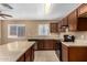 Bright kitchen features wood cabinetry, stone countertops, stainless steel appliances, and tiled flooring at 23682 W Bowker St, Buckeye, AZ 85326
