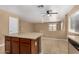 Open-concept living room features tile flooring and a view of the kitchen island, and backyard at 23682 W Bowker St, Buckeye, AZ 85326