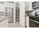 Well-organized kitchen with stainless steel refrigerator and microwave and a door leading to the pantry at 25876 N 162Nd Dr, Surprise, AZ 85387
