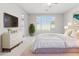 Serene main bedroom featuring neutral tones, a large window, and a dresser with a television at 25876 N 162Nd Dr, Surprise, AZ 85387