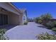 Paver patio leads to the backyard with mature landscaping, a brick privacy wall, and blue sky above at 2811 S Jeffry St, Gilbert, AZ 85295