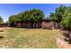 Beautifully landscaped backyard with mature trees, a well-manicured lawn, and a serene outdoor setting at 3705 W Villa Theresa Dr, Glendale, AZ 85308