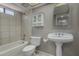 Compact bathroom with a tiled shower, pedestal sink, and storage cabinet at 3705 W Villa Theresa Dr, Glendale, AZ 85308