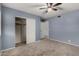 This bedroom features a ceiling fan, closet, carpet, and blue painted walls at 3705 W Villa Theresa Dr, Glendale, AZ 85308