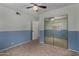 A two-toned bedroom with carpeting featuring a ceiling fan and a mirrored closet at 3705 W Villa Theresa Dr, Glendale, AZ 85308