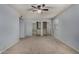 A carpeted bedroom featuring a ceiling fan, a window, and a large closet at 3705 W Villa Theresa Dr, Glendale, AZ 85308