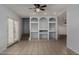 Bright living room with tiled flooring, built-in shelving, and a ceiling fan at 3705 W Villa Theresa Dr, Glendale, AZ 85308