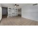 Bright living room featuring neutral tile floors, ceiling fan, and attractive built-in shelving at 3705 W Villa Theresa Dr, Glendale, AZ 85308