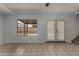 Bright living room featuring neutral tile floors, access to the yard, and staircase access to the second floor at 3705 W Villa Theresa Dr, Glendale, AZ 85308