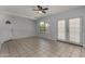 Bright living room featuring neutral tile floors, a ceiling fan, and a back door with access to the yard at 3705 W Villa Theresa Dr, Glendale, AZ 85308