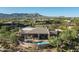 Aerial view of estate, showcasing pool, patio, and desert landscape against a mountain backdrop at 39089 N 102Nd Way, Scottsdale, AZ 85262