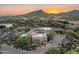 Panoramic aerial view of estate featuring a pool, mature trees, and desert landscape at sunset at 39089 N 102Nd Way, Scottsdale, AZ 85262