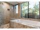 Spa-like bathroom featuring granite tile, soaking tub, and backyard views at 39089 N 102Nd Way, Scottsdale, AZ 85262