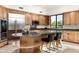 Well-equipped kitchen featuring wood cabinetry, stone countertops, and a center island with seating at 39089 N 102Nd Way, Scottsdale, AZ 85262