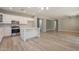 Open-concept kitchen with white cabinets, stainless steel appliances, and wood floors at 408 W Sweet Shrub Ave, San Tan Valley, AZ 85140