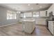 Bright kitchen featuring white cabinets, an island, modern appliances, and wood floors at 408 W Sweet Shrub Ave, San Tan Valley, AZ 85140