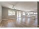 Open-concept living area with wood floors, neutral walls, with kitchen in the background at 408 W Sweet Shrub Ave, San Tan Valley, AZ 85140