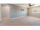 Carpeted loft space featuring a ceiling fan, TV mount, and a window at 408 W Sweet Shrub Ave, San Tan Valley, AZ 85140
