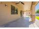 A spacious covered patio with ceiling fan, concrete floors, and easy access to the yard at 408 W Sweet Shrub Ave, San Tan Valley, AZ 85140