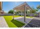 Beautiful backyard with a pergola, artificial grass, and desert landscaping at 408 W Sweet Shrub Ave, San Tan Valley, AZ 85140