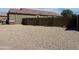 Fully enclosed backyard with desert rock landscaping and a tall privacy wall at 42087 W Manderas Ln, Maricopa, AZ 85138