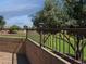 A backyard features a well-maintained lawn with a decorative retaining wall and wrought iron fence at 42087 W Manderas Ln, Maricopa, AZ 85138