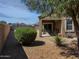 Desert landscaped backyard with covered patio and mature foliage at 42087 W Manderas Ln, Maricopa, AZ 85138