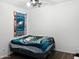 Bedroom featuring wood-look floors, a cozy Eagles-themed bedspread and ceiling fan at 42087 W Manderas Ln, Maricopa, AZ 85138