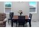Bright dining room with tile floors, large windows, and a wooden dining table with black chairs at 42087 W Manderas Ln, Maricopa, AZ 85138