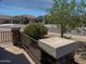 Street view of a desert home with mature foliage, ironwork fencing, and desert rock landscaping at 42087 W Manderas Ln, Maricopa, AZ 85138