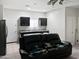 A living room featuring a black reclining sofa with a partial view of the kitchenette at 42087 W Manderas Ln, Maricopa, AZ 85138