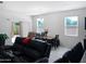 A bright living room that flows into the dining area, featuring tile floors and a comfortable seating arrangement at 42087 W Manderas Ln, Maricopa, AZ 85138