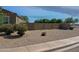 Desert landscaped side yard featuring a well-maintained rock bed, block wall and mature foliage at 42087 W Manderas Ln, Maricopa, AZ 85138