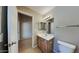 Bathroom features a sink, a vanity with wood cabinets, and a large mirror at 4776 W Eva St, Glendale, AZ 85302