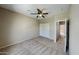 A neutrally decorated bedroom with a ceiling fan, closet, and carpeted flooring at 4776 W Eva St, Glendale, AZ 85302