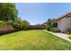 Lush backyard with green lawn, a walkway and flowering bushes, great for entertaining at 10807 W Morten Ave, Glendale, AZ 85307