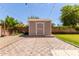 Charming backyard with shed, string lights, and stone patio area, ideal for relaxation at 10807 W Morten Ave, Glendale, AZ 85307