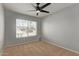 Neutral bedroom with a ceiling fan, carpet flooring, and natural light from the window at 10807 W Morten Ave, Glendale, AZ 85307