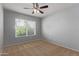 Empty carpeted bedroom with ceiling fan and a window providing natural light at 10807 W Morten Ave, Glendale, AZ 85307